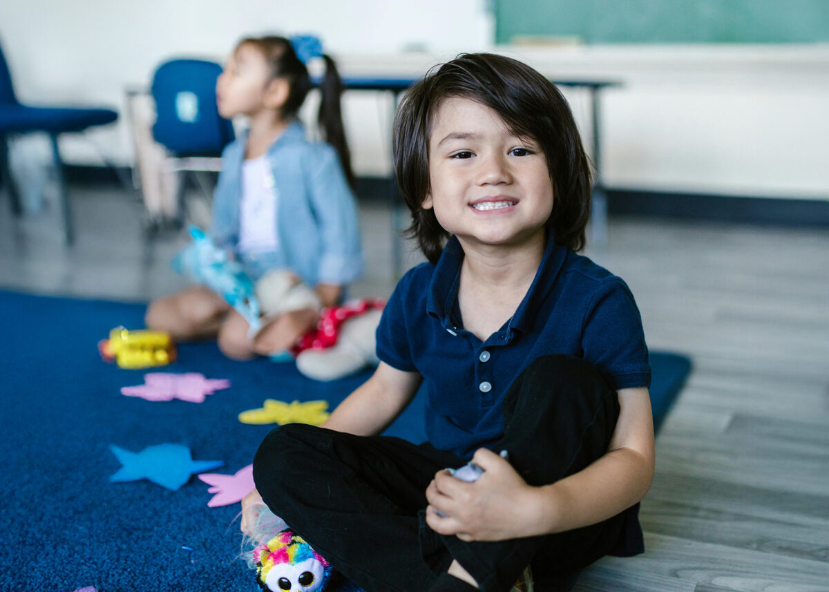 Un garçons à la maternelle 5 ans qui souris
